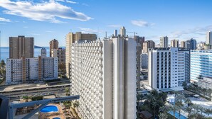 Ein hoch aufragendes Hotel mit moderner Architektur, das durch eine markante vertikale Struktur und einen Pool im Vordergrund gekennzeichnet ist.