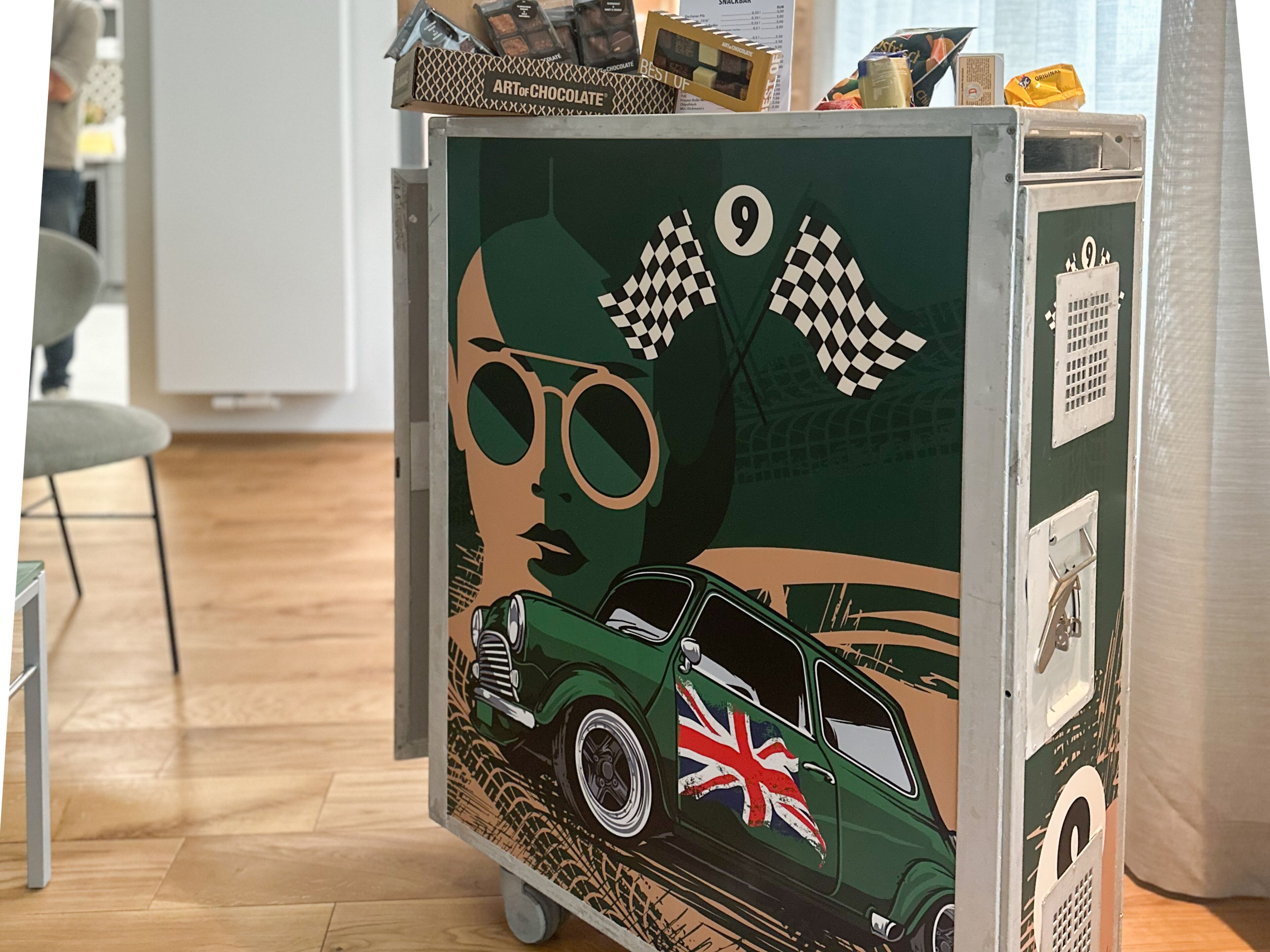Een klassieke auto met een Union Jack vlag op een groene muur.