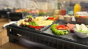 Un buffet proposant une variété de fromages, de fruits et de légumes.
