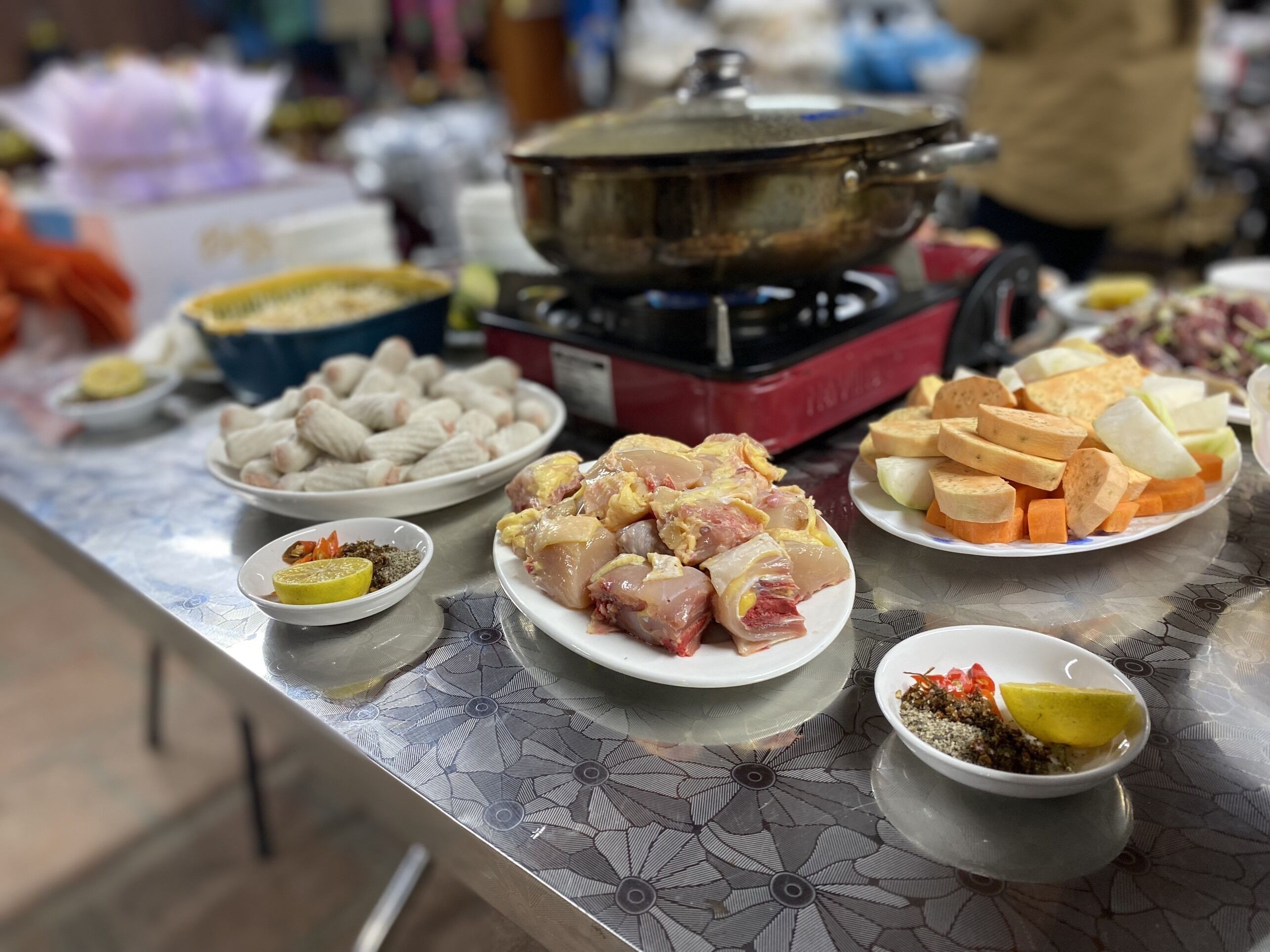 Una mesa con diversos alimentos, incluyendo pollo crudo, tofu y verduras.