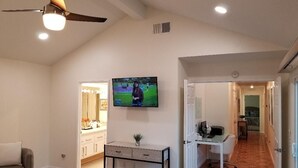 A bedroom with a TV, a desk, and a chair. - Private pool, spa, waterfall, firepit, BBQ, tennis, gym, hiking trails, casino (Palm Desert)