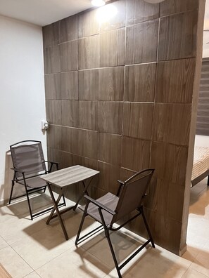 Compact room with a small table and two chairs, ideal for short stays or meetings.