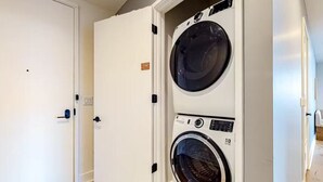 A laundry room with two stacked front-loading washing machines.