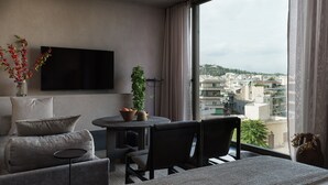 Una sala de estar moderna con un sofá, sillas, una mesita y un televisor.