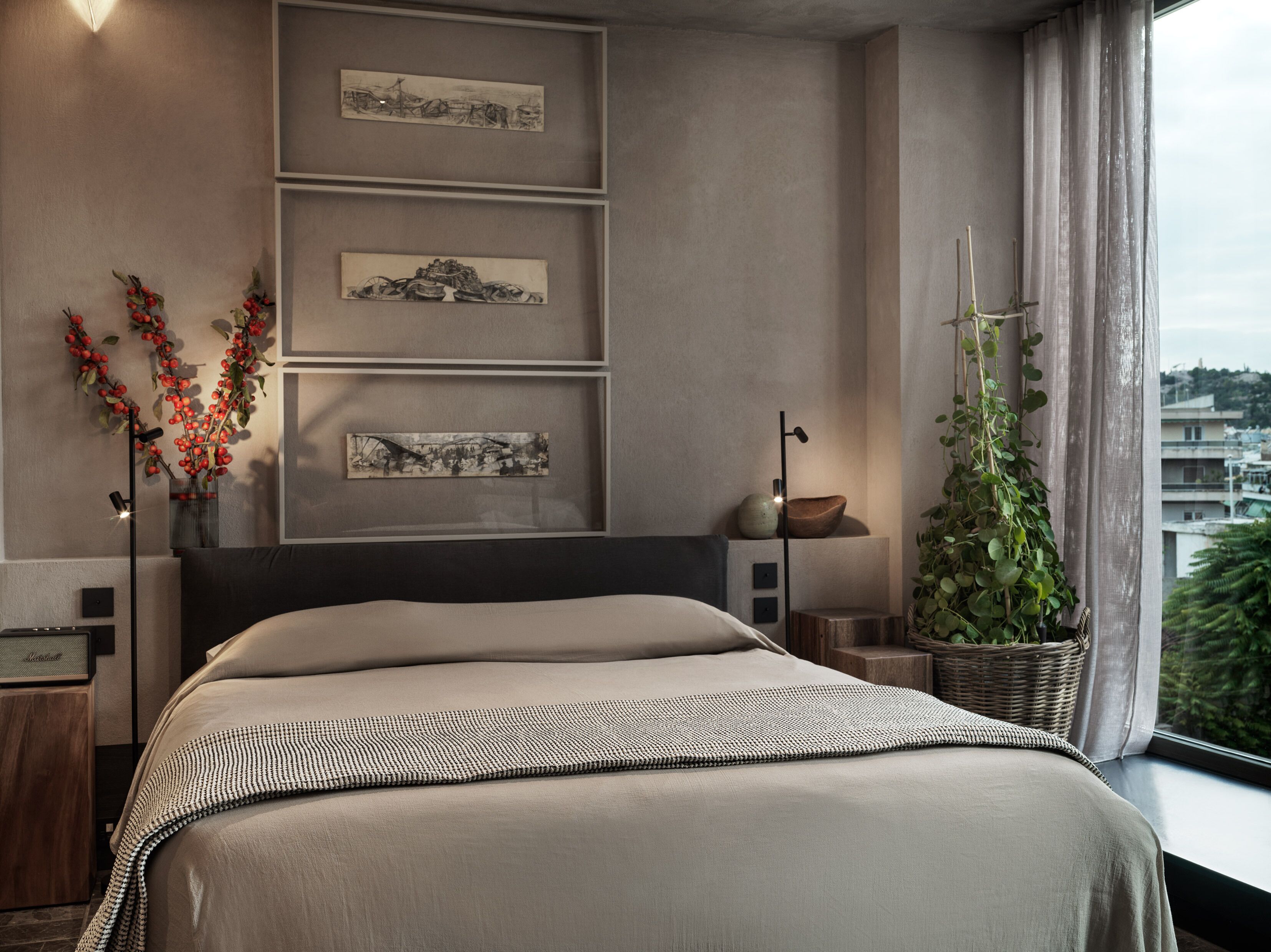 A modern bedroom with a large bed, a nightstand, a floor lamp, and artwork on the wall.