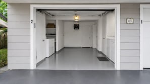 A garage with a clean, white interior, a light fixture, and a door marked with the number 225.