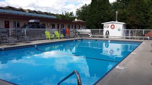 Relax by the rectangular pool surrounded by lounge chairs and a lifeguard station.