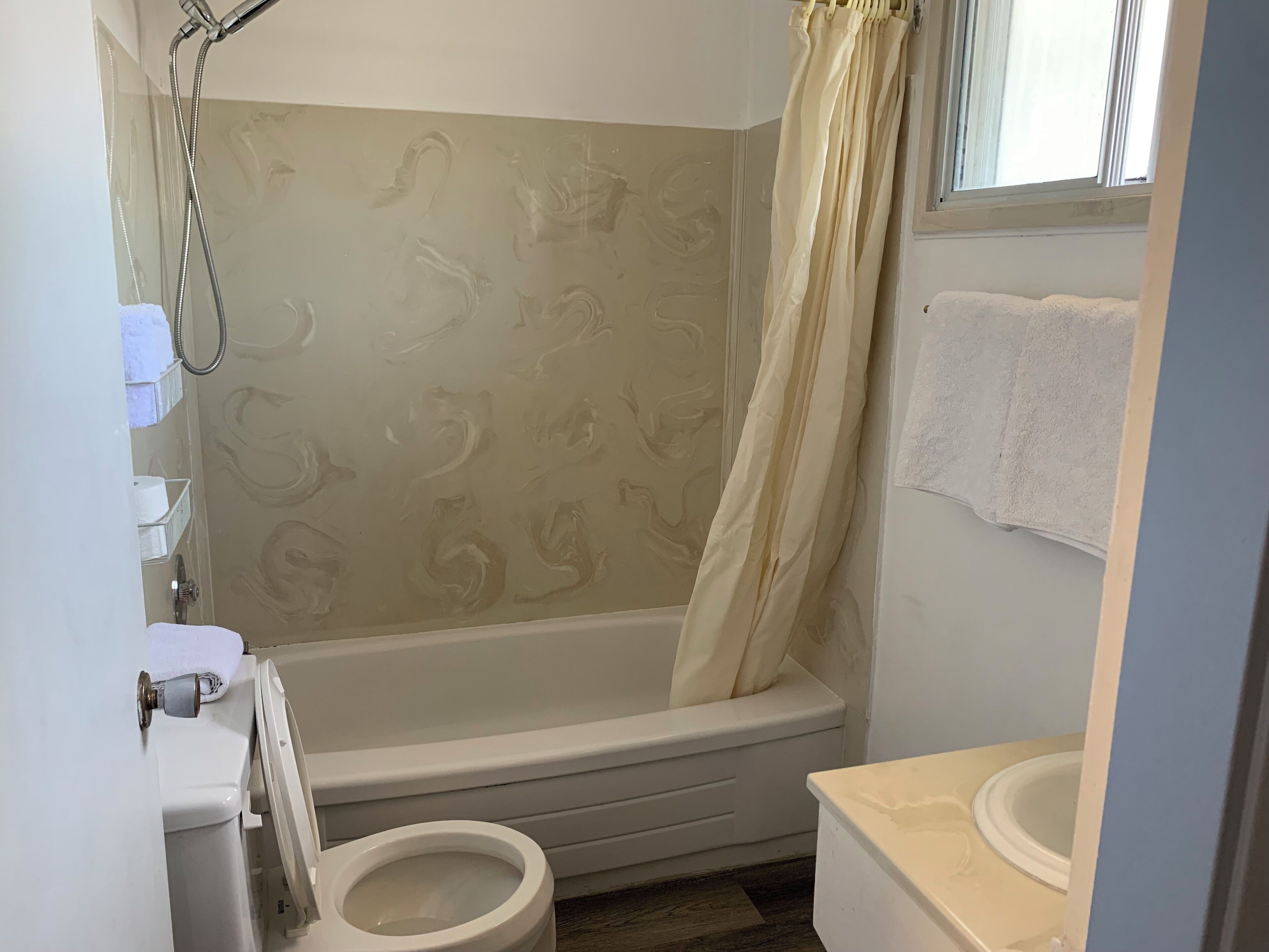 A bathroom with a bathtub, toilet, and sink.