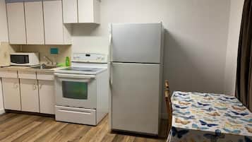 Frigorífico grande, horno, placa de cocina y utensilios de cocina