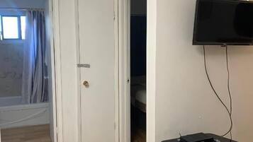 Suíte econômica, 2 camas Queen | Área de estar | TV de tela plana