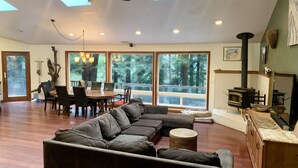 A spacious living area with a large sectional sofa, a dining table with chairs, and a fireplace. - Large house Up in the Redwoods perfect for large families. Pet friendly.  (Fortuna)