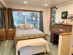 A bedroom with a bed, a piano, a TV, and a window with curtains. - Large house Up in the Redwoods perfect for large families. Pet friendly. (Fortuna)