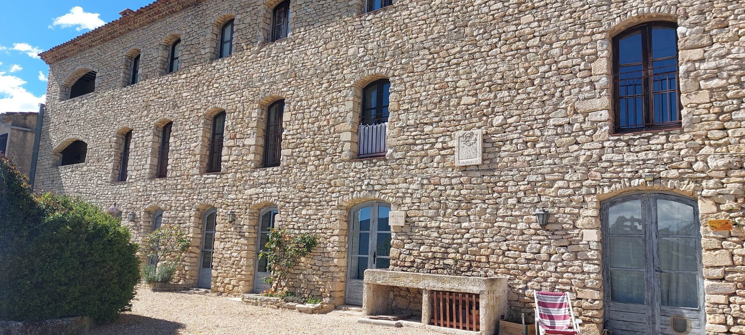 Un edificio de piedra con varias ventanas y una puerta.