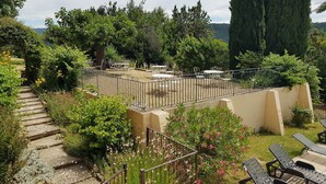 A garden patio with outdoor seating, a stone pathway, and a variety of plants and trees. - "LE COSY LUBERON" - VIENS (Viens)