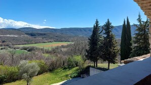 A view from a stone balcony overlooking a valley with trees and distant mountains. - "LE COSY LUBERON" - VIENS (Viens)