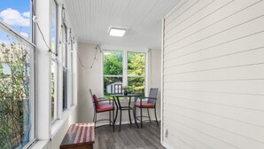 A room with a table and chairs, large windows, and a view of greenery outside. - Cozy W Front Porch DT Libertyville near Naval Base (Libertyville)