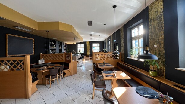 A restaurant with booths, tables, and a bar area. - Upper-House (Aystetten)