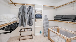Un dormitorio ordenado con cama, un cambiador, un armario y una cuna.