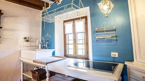 Une cuisine avec un plan de travail blanc, une cuisinière et des luminaires suspendus.