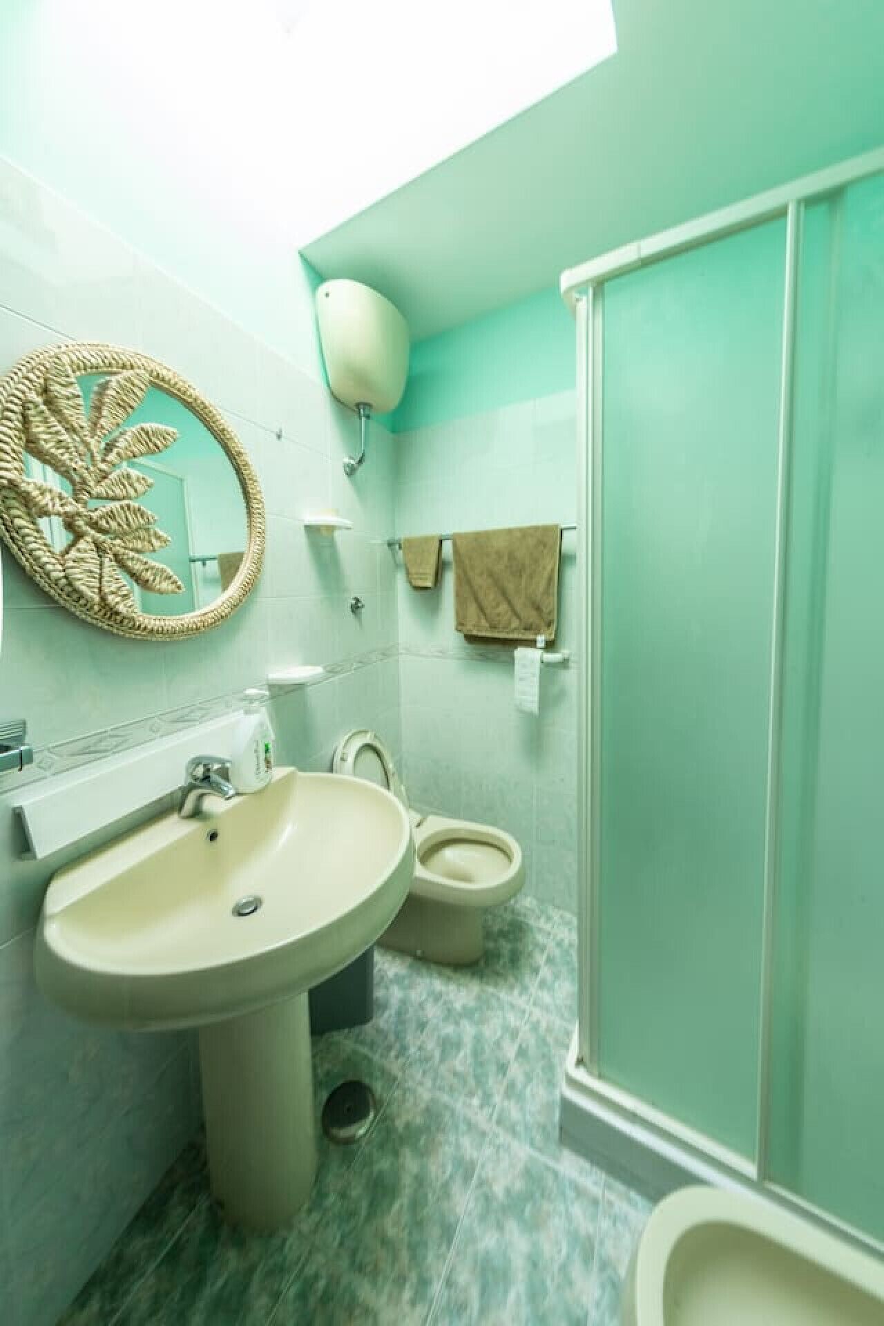 Une salle de bain avec un lavabo, des toilettes et une douche.