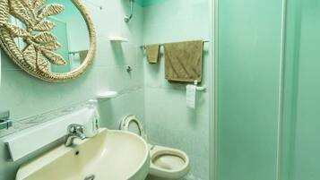Une salle de bain avec un lavabo, des toilettes et une douche.