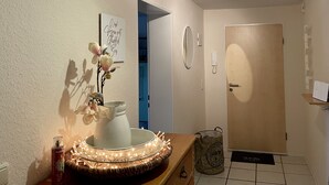 A bathroom with a sink, mirror, and a wall-mounted light fixture.