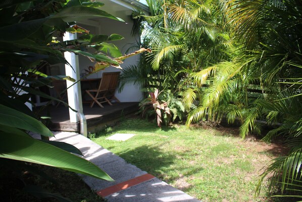 A garden with a pathway leading to a covered seating area.