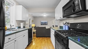 A compact kitchen with a microwave, stove, and sink. - Charming apt in DT Libertyville - Near Naval Base (Libertyville)