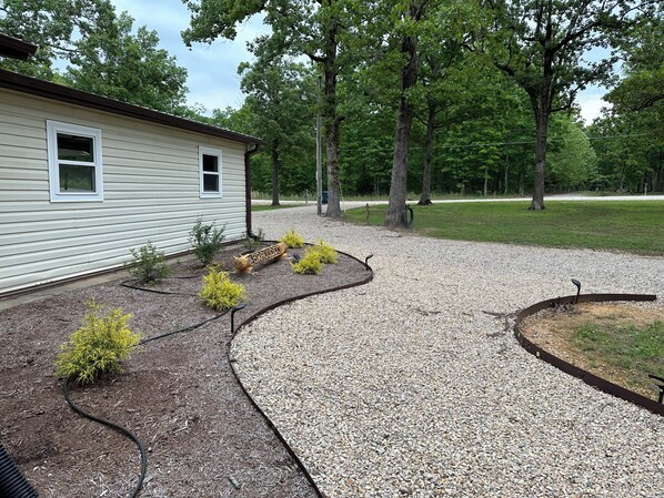 A house with a gravel driveway and a landscaped garden with small shrubs. - Cozy 3-bedroom in Wappapello with AC, WiFi and close to the Lake. (Wappapello)