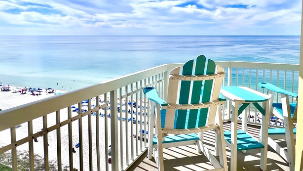 Ein Balkon mit Blick auf Strand und Meer.