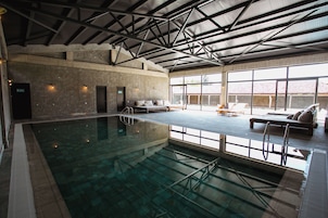 Una piscina techada, sillones reclinables de piscina