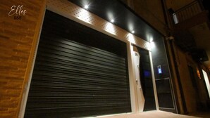 Puerta de garaje cerrada con persiana metálica, pared de ladrillo y marco de madera.