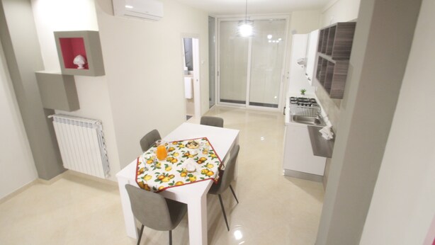 Una cocina compacta con comedor, un radiador y una lámpara en el techo.