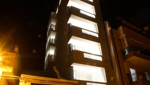 Un edificio alto con ventanas iluminadas durante la noche.