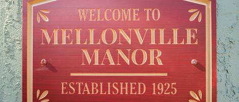 A wooden welcome sign for Mellonville Manor, established in 1925.