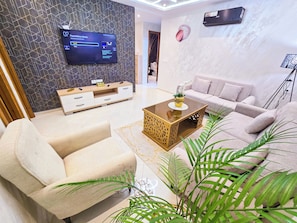 Elite appartement | Woonruimte | Een 65-inch flatscreentelevisie met satellietzenders en Netflix