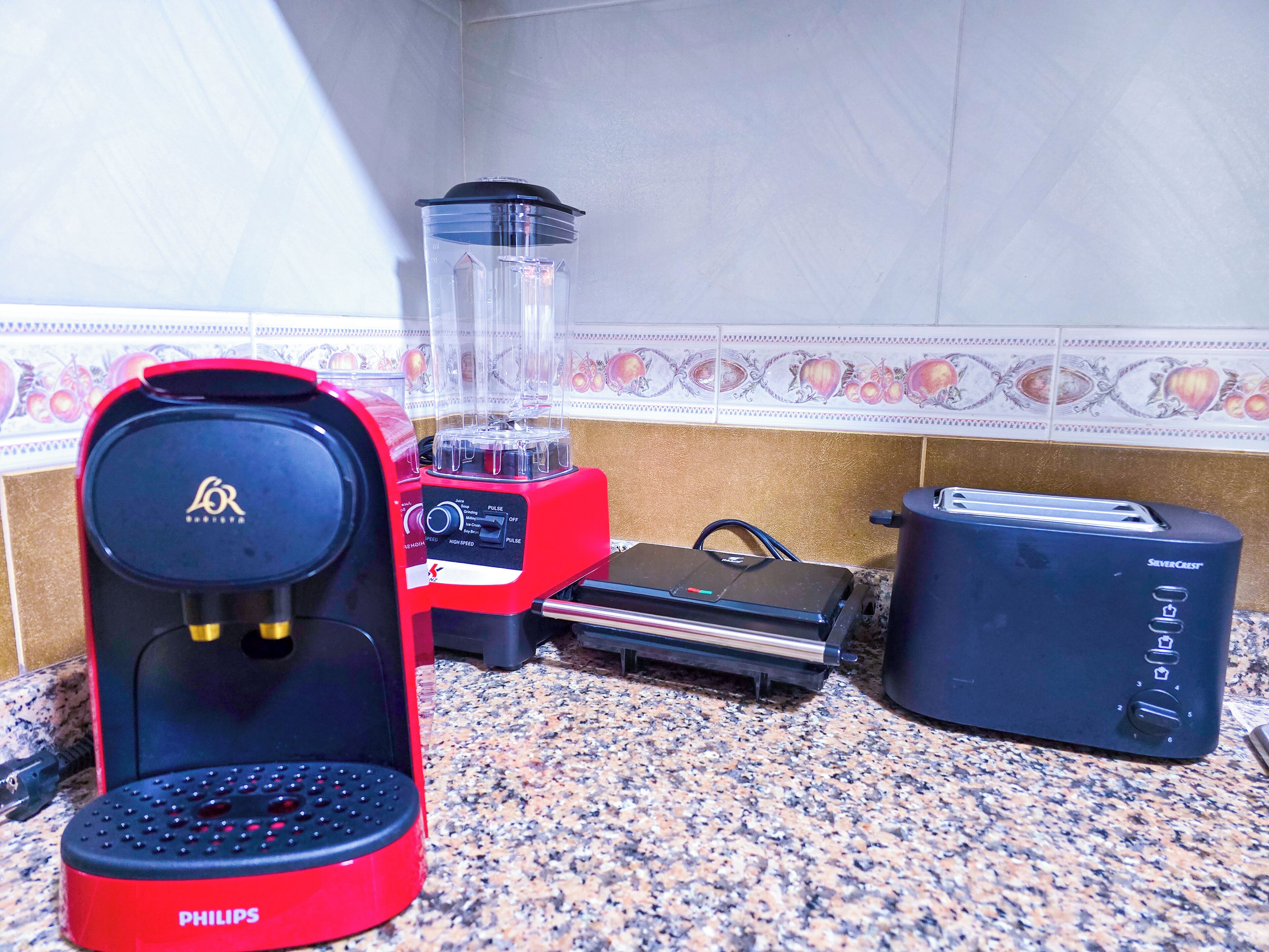 Uma cozinha equipada com cafeteira, liquidificador, torradeira e chaleira.
