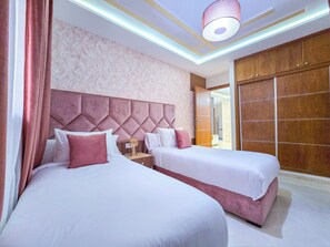 Habitación de hotel con dos camas, un armario grande y un diseño moderno en el techo.