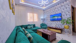 Leilighet – deluxe, aircondition | Oppholdsområde | En 65-tommers Flatskjerm-TV med Parabol-TV samt Netflix