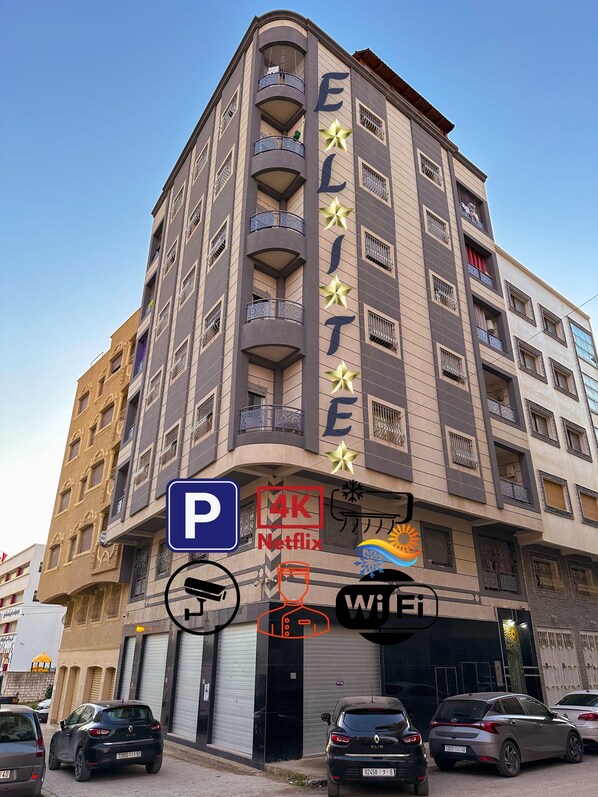 Un edificio de varios pisos con balcones, un letrero de Netflix en 4K y un símbolo de Wi-Fi.