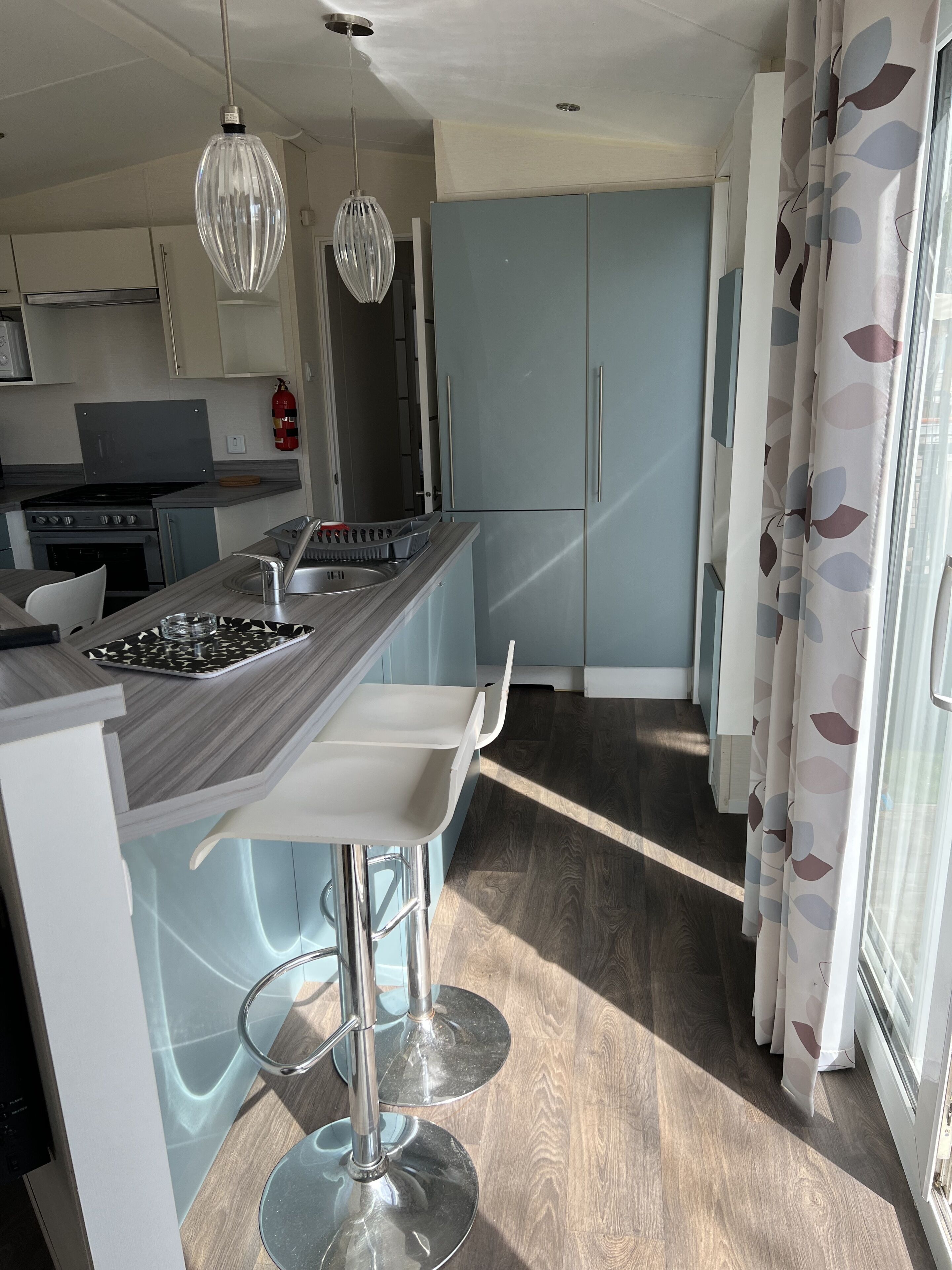 A modern kitchen with a central island, stainless steel appliances, and pendant lighting.