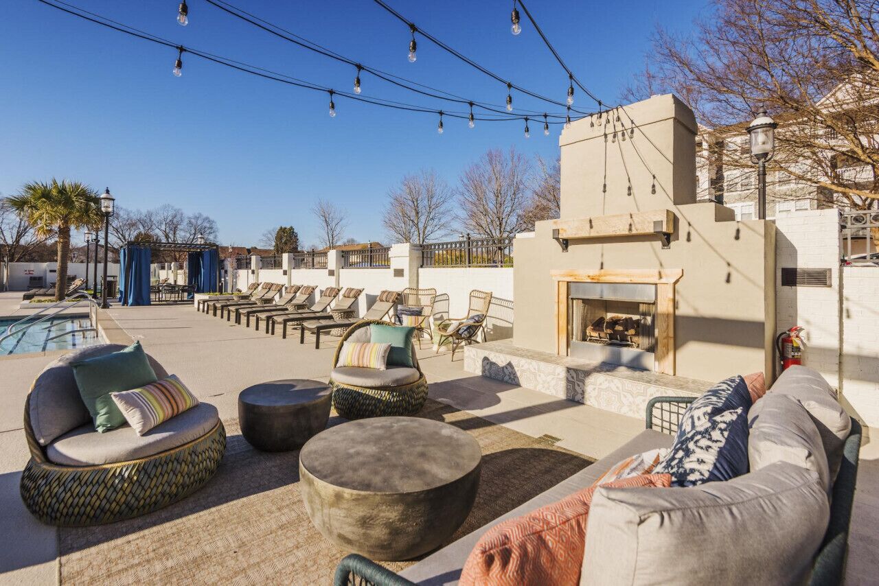 Eine Dachterrasse mit Sitzgelegenheiten im Freien, einem Pool und Lichterketten.