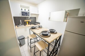 Prepare meals and dine in comfort with a central island and bar stools in this compact kitchen.