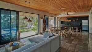 Een moderne keuken met een groot eiland en een eethoek met een houten tafel en stoelen.