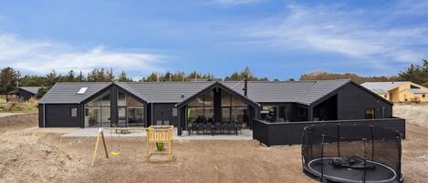 Een modern gebouw met grote ramen en een overdekt terras.