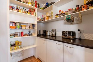 Kitchen area with toaster, coffee maker, and kettle, offering a convenient space for food preparation and storage.