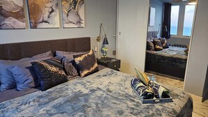Ein Schlafzimmer mit Bett, Nachttisch, Lampe und Spiegel.