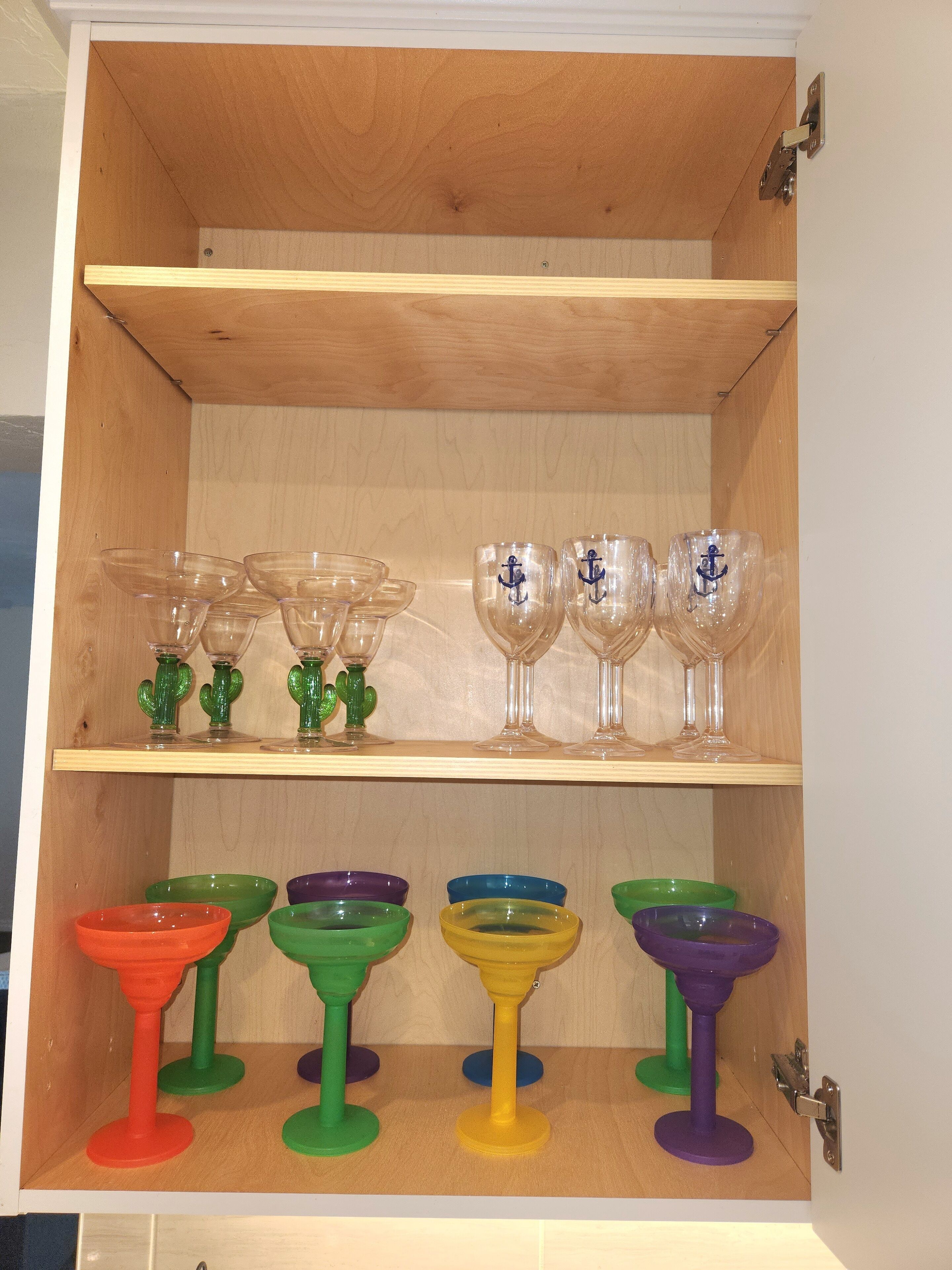 Ein Holzkabinent mit zwei Regalen, auf denen verschiedene Gläser stehen.