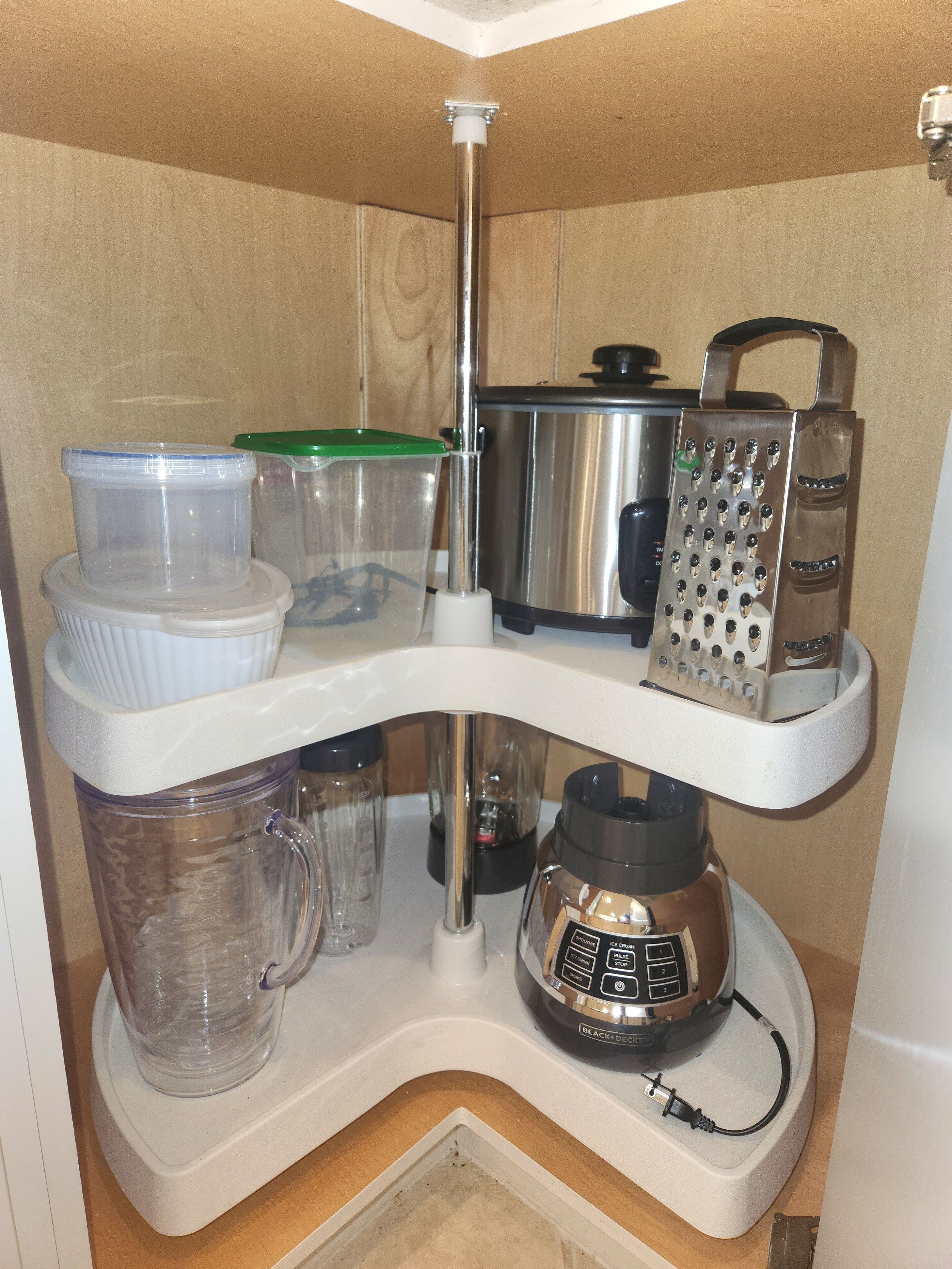 A kitchen with a built-in shelf holding various containers, a blender, and a grater.