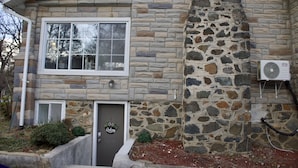 A stone house with a chimney, a front door, and a window.